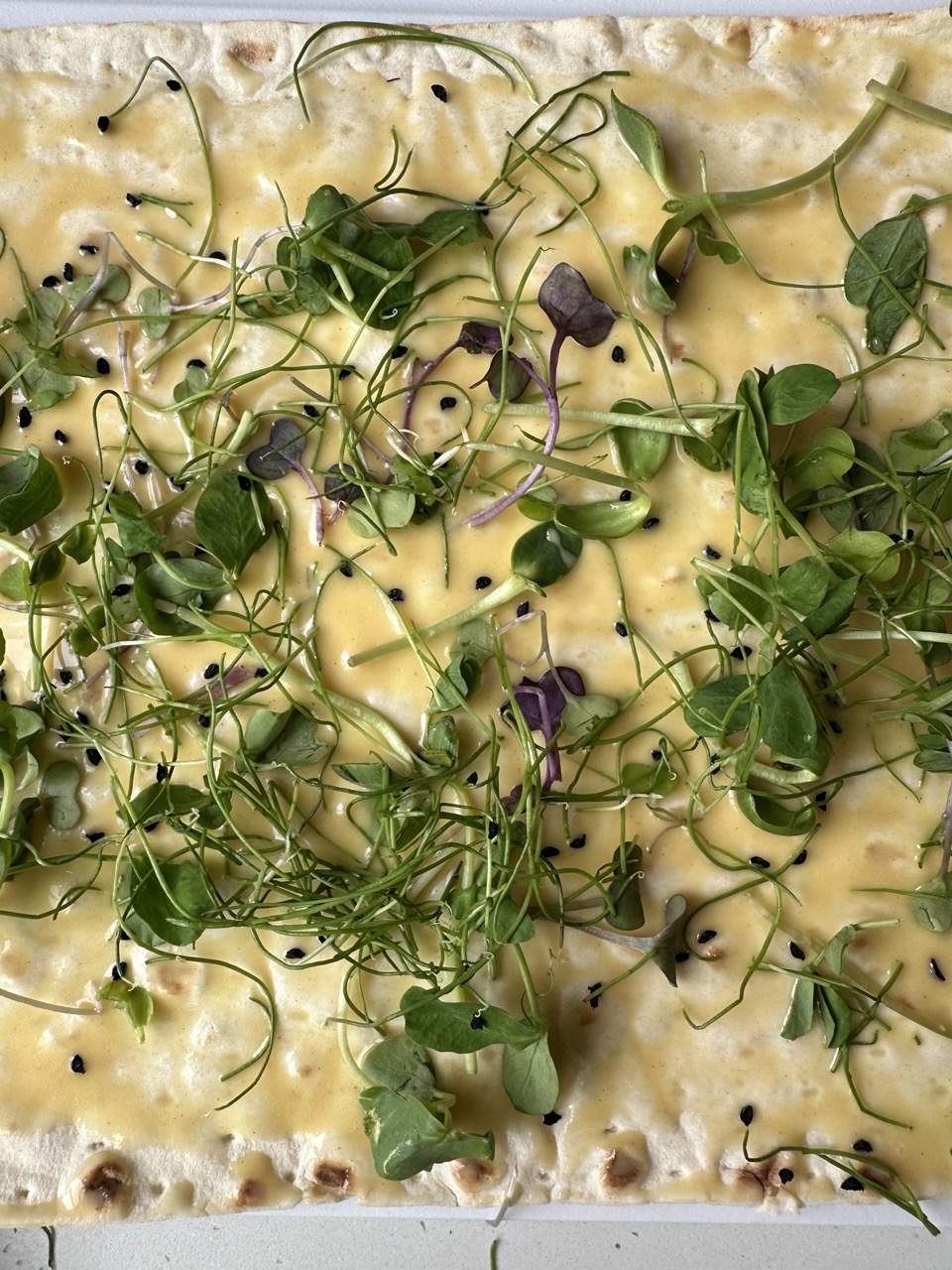 close up image of microgreens sprinkled over lavash